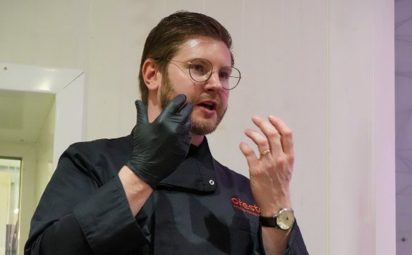 Een close-up van een man met een bril en een donker uniform met 