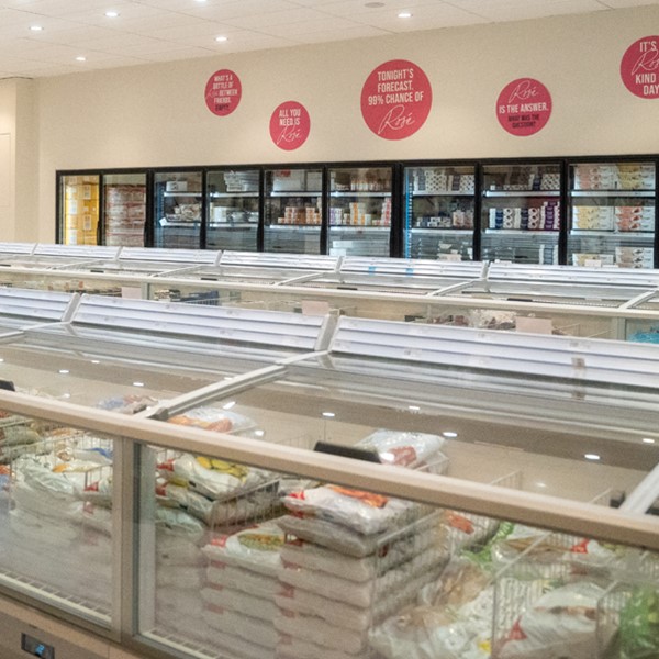 Een commerciële open vrieskist in een supermarkt, gevuld met diverse diepvriesverpakkingen.
e